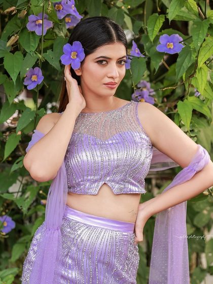 A designer shoot for a modern lavender lehenga. The images were taken in a lush garden, with the purple flowers complementing the color of the outfit, creating a soft and romantic fashion story.