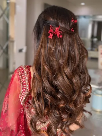 A side view of the romantic half-updo, highlighting the soft texture of the waves and the delicate floral details.
