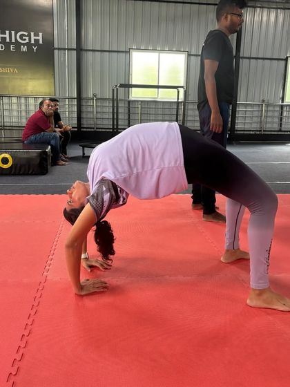 A participant in our workshop practices her backbend, a key focus of our flexibility training.