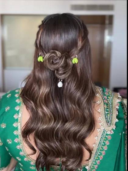 A back view of the half-updo for Dandiya night, featuring a rose-shaped bun and shell accessories for a unique, festive touch.