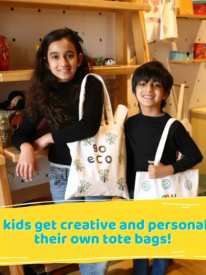 Two siblings proudly display their eco-friendly tote bags. This activity also opens up conversations about sustainability and reusing materials.