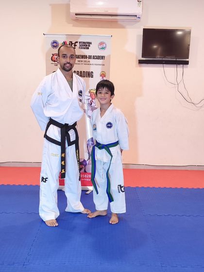 A student and coach pose after a successful grading. We celebrate every step of the journey.