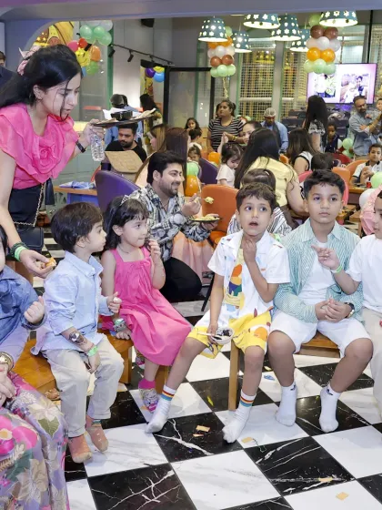 Kids and adults mingle in our cafe area during a party, enjoying snacks and conversation between play sessions.