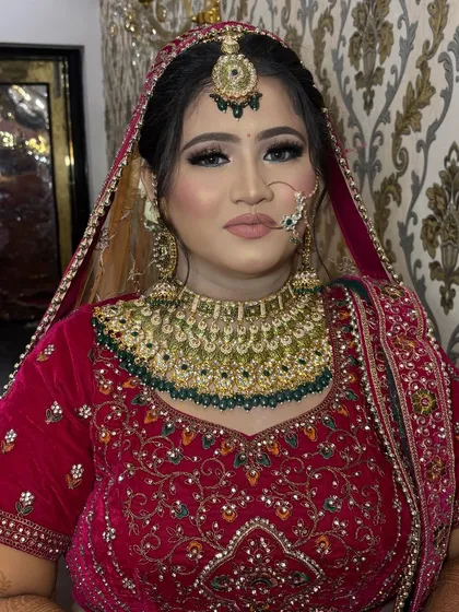 This bride's look is a perfect example of traditional elegance. The makeup is classic, with a winged liner and a soft nude lip that balances her heavy jewellery.