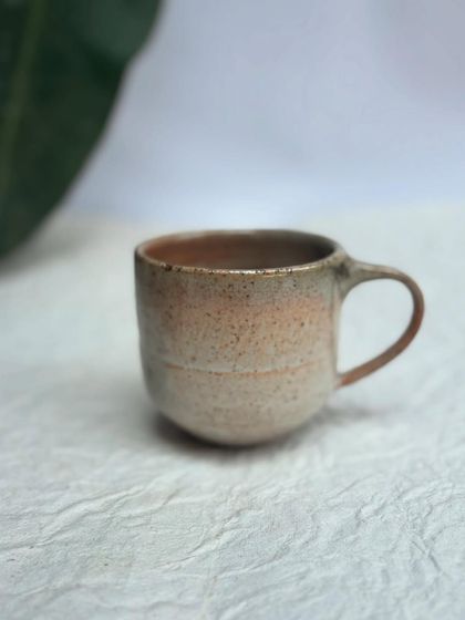 Introducing our Shino glaze on a rounded cup form. This glaze has a light sheen on the inside and a beautiful crackle texture on the outside.
