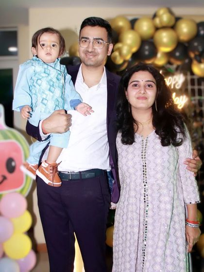 A classic portrait of a mother, father, and their young child at a family gathering.