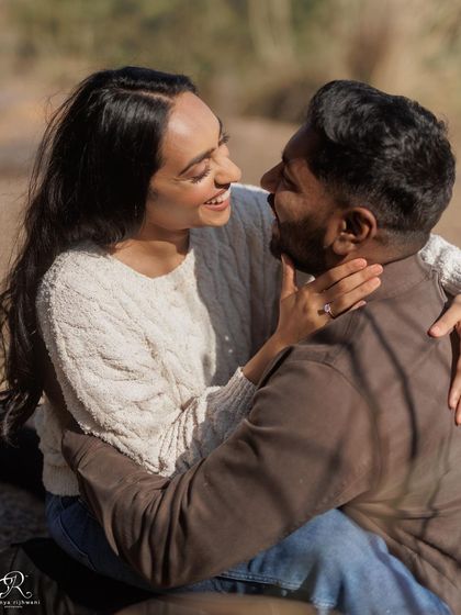 A playful and intimate moment from their engagement session. Her joyful expression and their close embrace make this a wonderfully candid and emotional photograph.