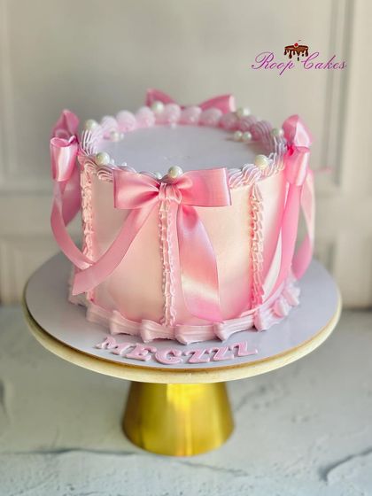 A pretty pink cake for a 21st birthday. This elegant design is decorated with delicate piping and beautiful satin ribbon bows, creating a soft and feminine look.