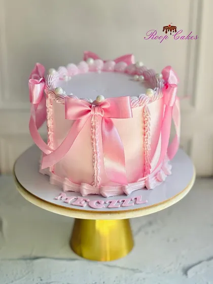 A pretty pink bow cake for a 21st birthday. This design features soft pink frosting and is decorated with delicate satin-like ribbons.
