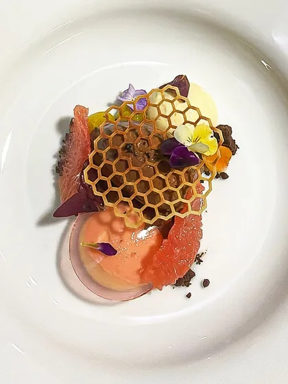 Dessert is the final act of the dining experience. This Parfait of Cardamom is paired with a light cacao mousse, fresh pomelo, and a delicate honeycomb tuile for a complex and satisfying conclusion to the meal.
