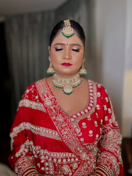 A close-up on the details. Shimmery eyes and a bold red lip create a powerful and traditional bridal look that perfectly matches her skin tone and ornate jewelry.