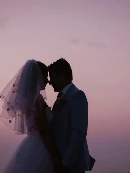 A quiet, intimate silhouette of the couple touching foreheads. This simple pose against the soft colors of the sunset sky is incredibly romantic and powerful.