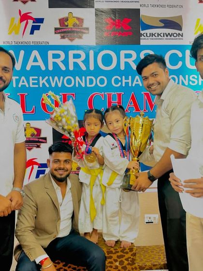 Our little champions on the winner's podium with a huge trophy. Their victory at the Warriors Cup is an inspiration for all our students.