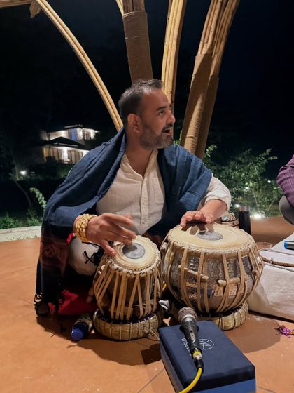 A musician playing the tabla during our kirtan night. The vibrations of live music and chanting create a powerful, meditative atmosphere that uplifts the spirit.