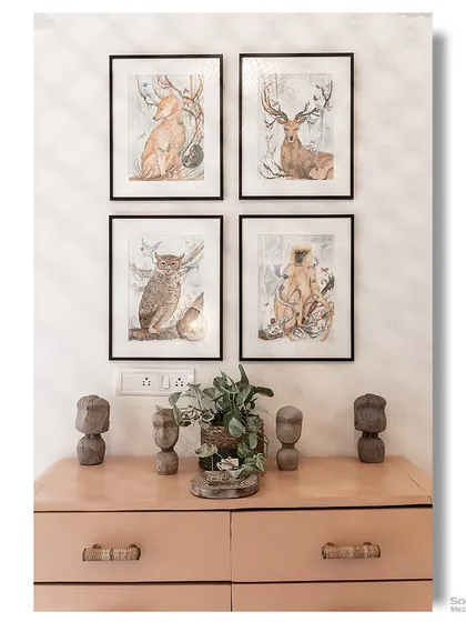 A charming vignette in a Goan homestay, with a peach-colored dresser and a collection of framed animal illustrations. The decor is playful, artistic, and thoughtfully curated.