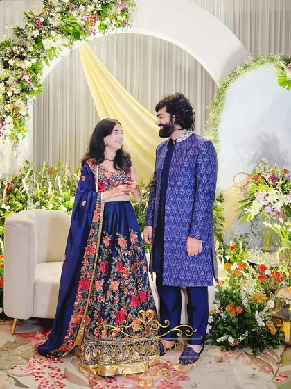 The happy couple, Tanya and Shavak, posing against the beautiful pastel floral backdrop of their Roka ceremony.