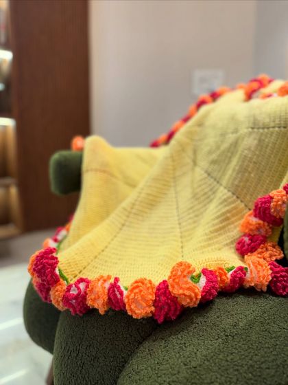 This carnation bouquet blanket in yellow and orange is another one of our floral-edged designs, perfect for adding a touch of spring to your home year-round.