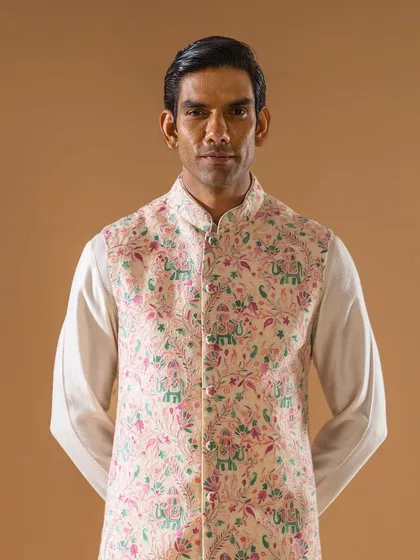 A frontal view of the pastel pink Jawahar jacket with whimsical embroidery. The detail of the elephants and florals is clearly visible, showcasing our commitment to unique design.