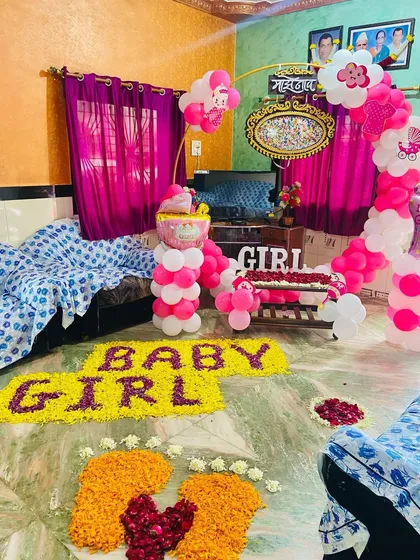 A close-up of the 'BABY GIRL' floor art made from flowers, with baby feet made of marigold and rose petals.