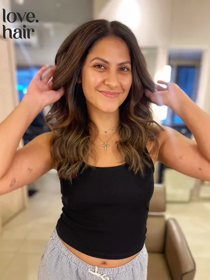 The client looking radiant with her new hair. This look is a perfect example of a modern, stylish balayage that enhances natural beauty.
