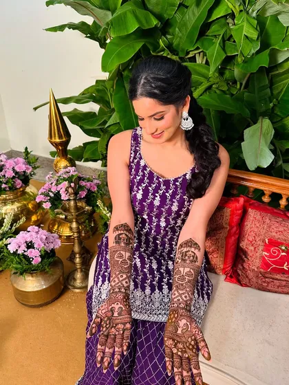 A client looking elegant in a purple outfit, her hands decorated with my intricate, traditional mehndi patterns.