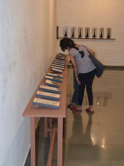 A close-up of a visitor examining the reverse paintings.