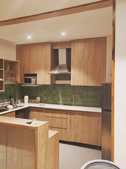 The interior of our prefab homes are designed for modern living. This kitchen features custom bamboo-finish cabinetry, a functional breakfast counter, and an efficient layout, proving that compact living can be both beautiful and practical.