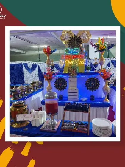 A vibrant and colorful buffet station designed for a celebration. The blue and white decor, combined with bright floral arrangements, creates a joyful and festive atmosphere.