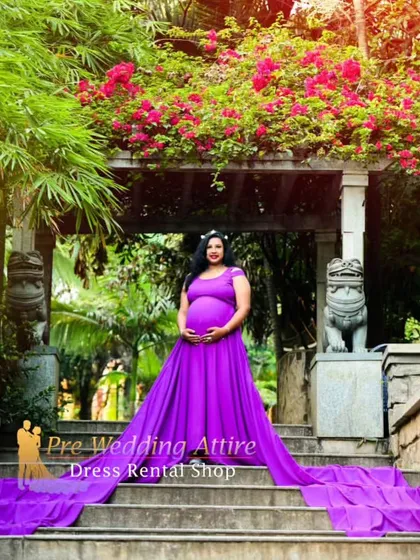 Make a grand entrance with this vibrant purple flowy gown. The extra-long train drapes beautifully down a staircase, creating a regal and unforgettable maternity portrait.