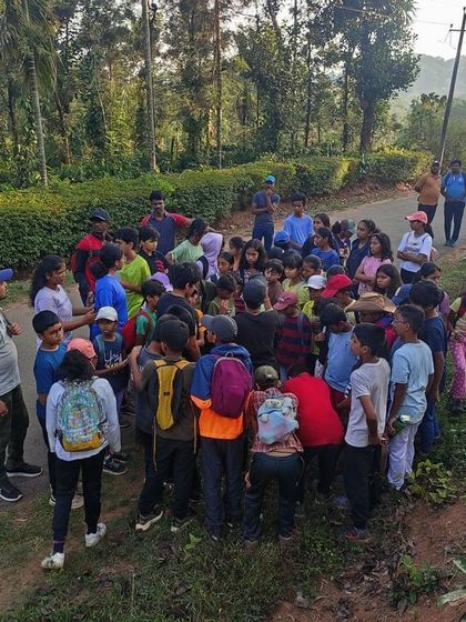 Campers gather around an instructor for a lesson in the wild during a trekking break.