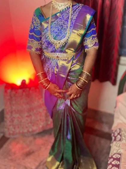 A full-length view of a bride in a magnificent multi-toned silk saree. The draping is done to showcase the beautiful color transitions in the fabric.