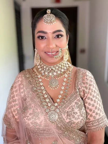 A beautiful portrait of our morning bride in a pastel peach lehenga, looking absolutely radiant and happy.