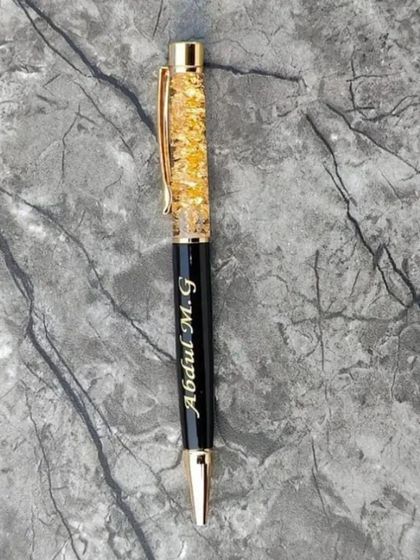 A close-up of the elegant gold-flaked personalized pen.