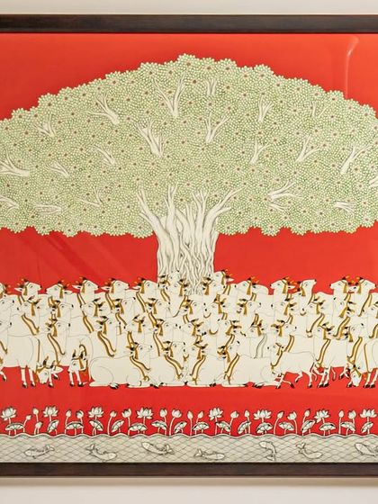 A close-up of the 'Tree of Life' artwork. This custom piece, with its intricate details and vibrant red background, serves as the heart of the dining space, symbolizing growth and harmony.