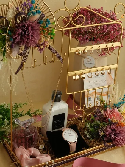 For the woman who appreciates style and self-care. This hamper features a curated selection of accessories like a watch and jewelry holder, paired with premium perfume and lotion. It’s a perfect example of a personalized luxury gift for her.