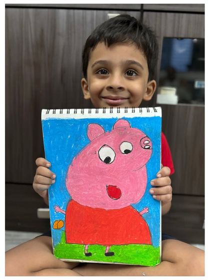 A pre-primary student shows his colourful drawing of the popular cartoon character Peppa Pig. Drawing familiar characters is a great way to build confidence and make art relatable for young kids.