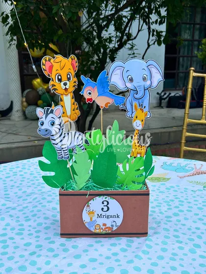 It's the little details that make a theme complete. This custom table centerpiece for a jungle party features adorable animal cutouts nestled in a box of greenery.