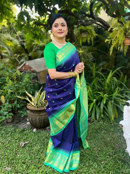 A full-length shot of Bhargavi in a beautiful blue and green saree.