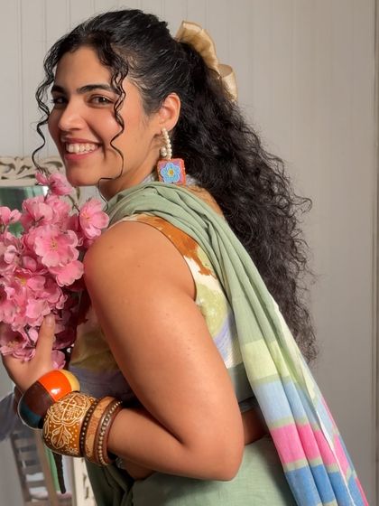 A happy, candid moment from the Dressfolk saree shoot. The colorful bangles and hand-painted earrings complete this vibrant, artistic look.