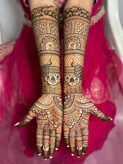 A full-coverage bridal mehendi with peacock figures and initial monograms. The intricate patterns and personalized touches make this design truly special for the bride.