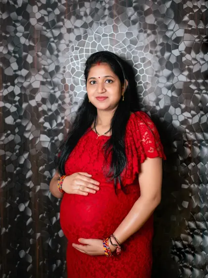 This studio portrait highlights the mom to be against a textured backdrop, adding depth and style to the image while keeping the focus on her radiant expression.