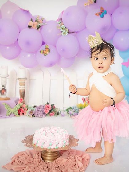 A little princess and her magical wand. This butterfly-themed first birthday shoot is full of whimsy and charm, with a beautiful pastel balloon backdrop.