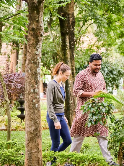 An Ayurvedic doctor guides a guest on a walk through our medicinal herb garden. This is part of our holistic approach, where we educate guests about the plants used in their treatments, connecting them directly to the source of their healing.