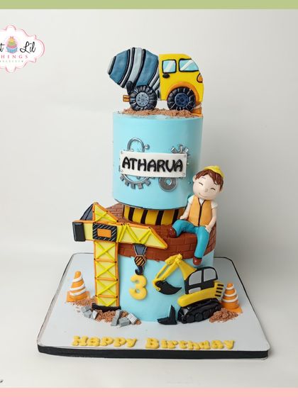 We're building sweet memories with this detailed construction-themed cake. The two-tiered design includes a crane, cement mixer, and an excavator, all handcrafted from fondant for a little builder's 3rd birthday.