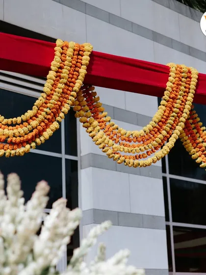 Detail of traditional marigold garlands used as decor, adding a pop of color and a traditional feel to the Mehendi venue.