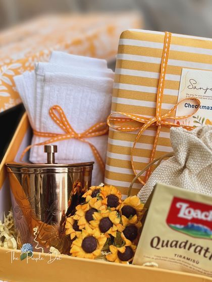 Inside the box, a warm and sunny theme with a brass tumbler, sunflower accents, and comforting treats.