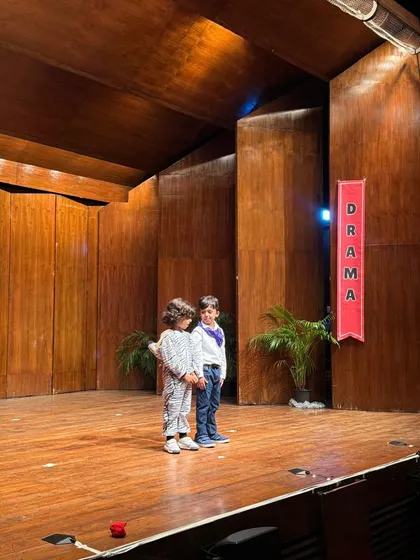 Two young actors share the stage, completely in character for their dramatic scene.