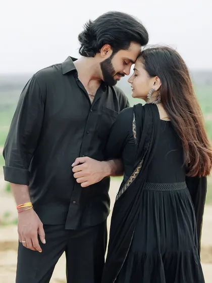 An intimate portrait in the sand dunes, with the couple in matching black outfits creating a classic and timeless look.