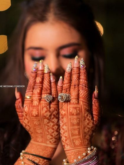 Mehendi night glam. These nails, adorned with glitter and stones, were designed to shine alongside the beautiful henna art, adding an extra layer of sparkle to the pre-wedding celebrations.
