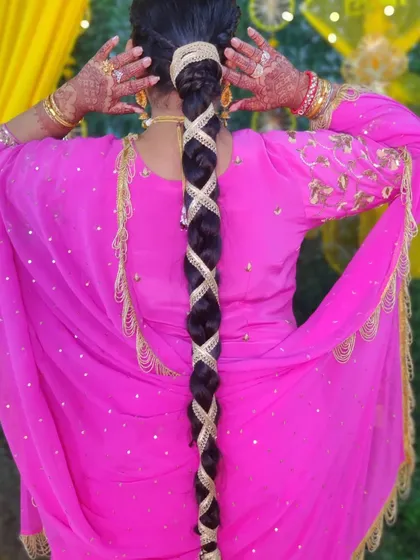 A very long, traditional Punjabi braid (parandi) wrapped with golden lace. This is a classic hairstyle for events like Lohri and looks incredibly regal.